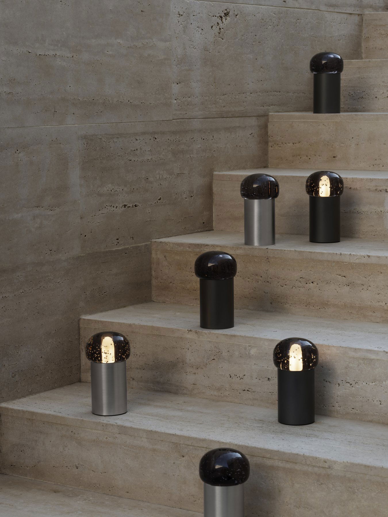 Stilvolle moderne Lampen in unterschiedlichen Höhen auf eleganten Steinstufen für zeitgemäße Dekoration.