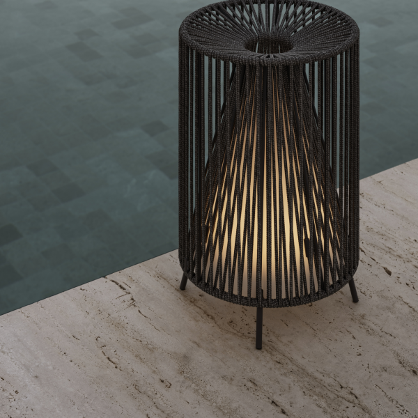 Stylische schwarze geflochtene Lampe neben einem ruhigen Pool, die die Außenatmosphäre verbessert.