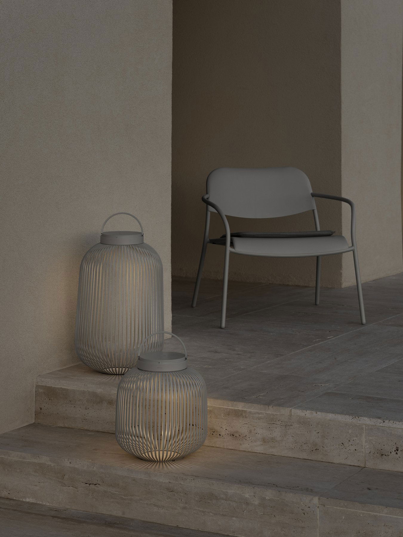 Stilvolle Außendekoration mit modernen Laternen und einem minimalistischen Stuhl auf einer Terrasse.