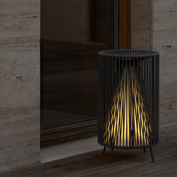 Moderne schwarze Lampe mit dekorativem Design, die einen gemütlichen Außenbereich beleuchtet.