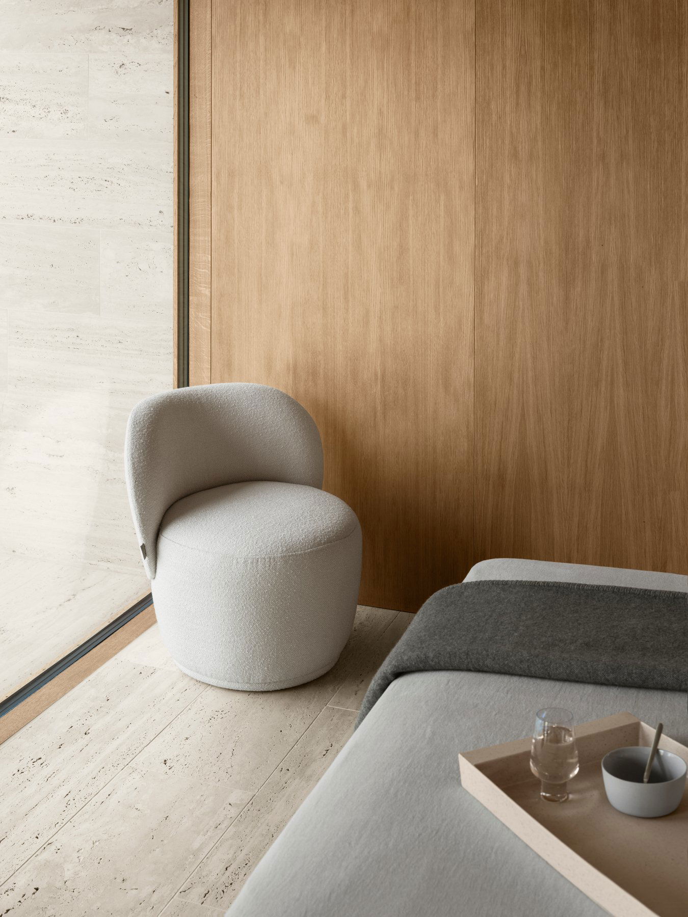 Gemütlicher, moderner Stuhl in einem minimalistischen Raum mit Holzwand und sanfter Beleuchtung.