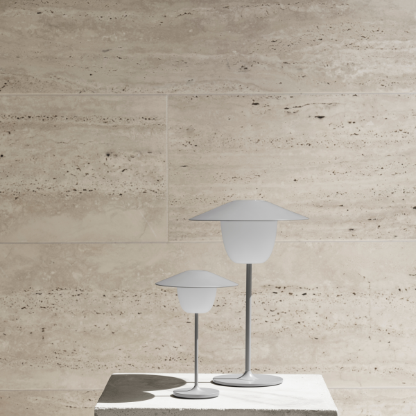 Moderne Tischlampen mit minimalistischem Design auf einem strukturierten Stein-Hintergrund.