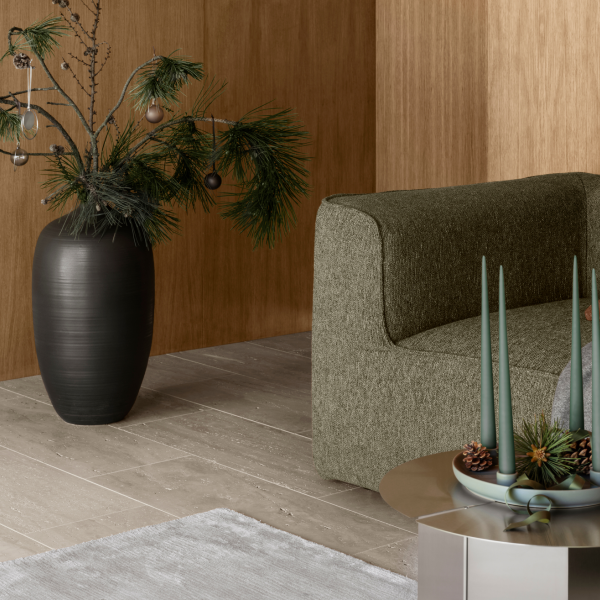 Stilvolles Wohnzimmer mit einem grünen Sofa, saisonaler Dekoration und einem modernen Holz-Hintergrund.