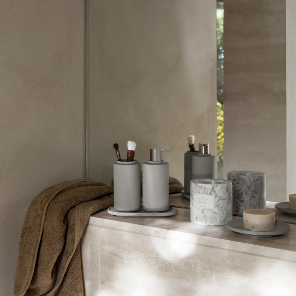 Modernes Badezimmerdekor mit grauen Accessoires und eleganten Marmorkerzen.