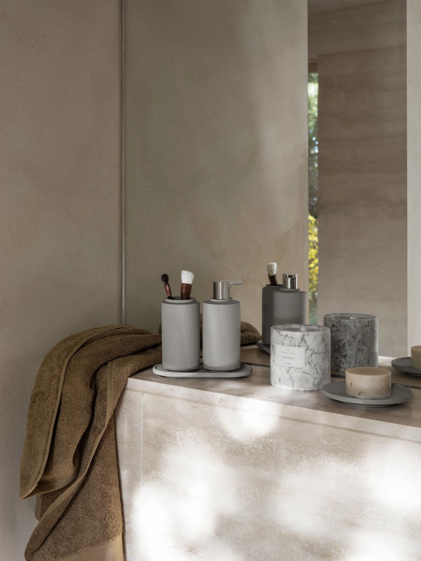 Modernes Badezimmerdekor mit grauen Accessoires und eleganten Marmorkerzen.