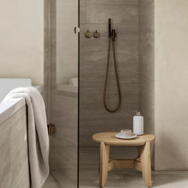 Elegant modern bathroom featuring a glass shower, wooden stool, and minimalist decor.