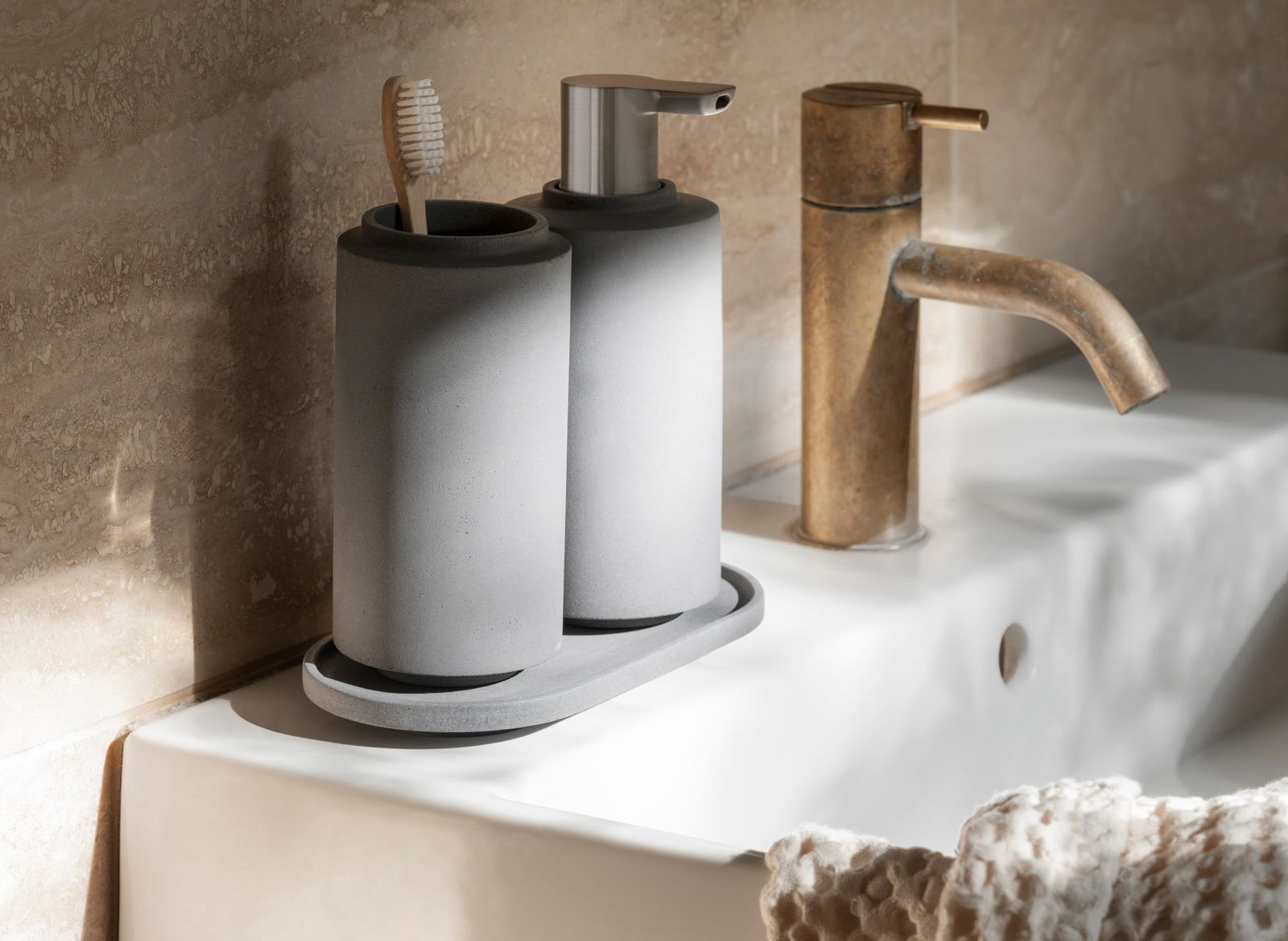Stylish gray bathroom accessories with toothbrush holder and liquid soap dispenser.