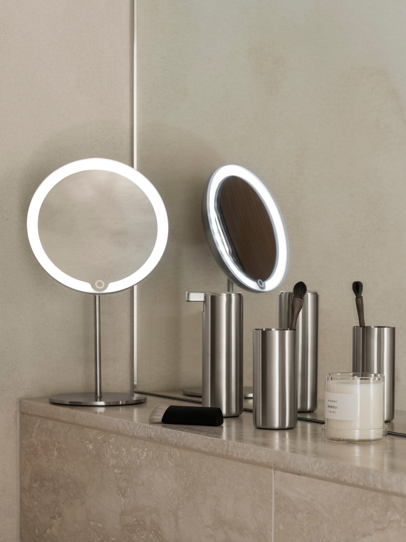 Moderner Schminkbereich mit beleuchteten Spiegeln und eleganten, metallischen Schönheitsaccessoires.