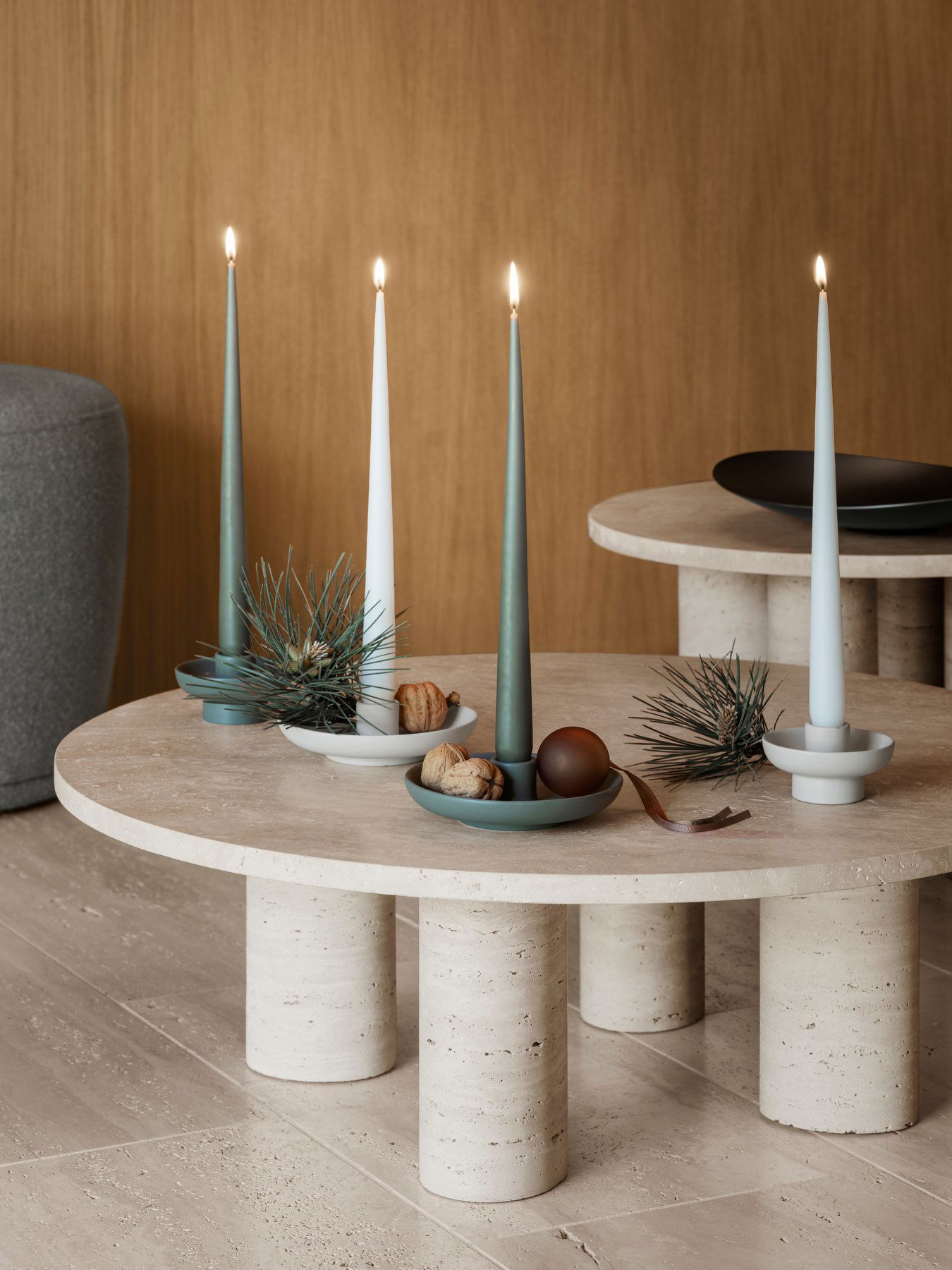 Stylish candles on modern tables with decorative plates and natural elements.