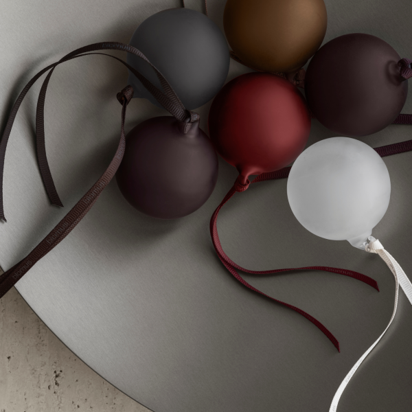 Bunte dekorative Kugeln auf einer glatten, modernen Fläche mit eleganten Bändern.