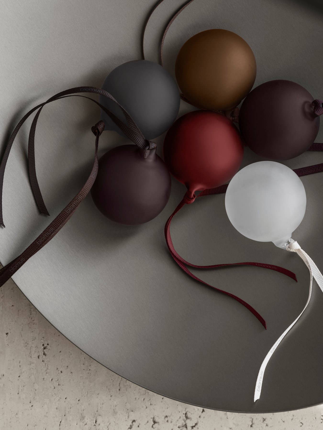 Bunte dekorative Kugeln auf einer glatten, modernen Fläche mit eleganten Bändern.