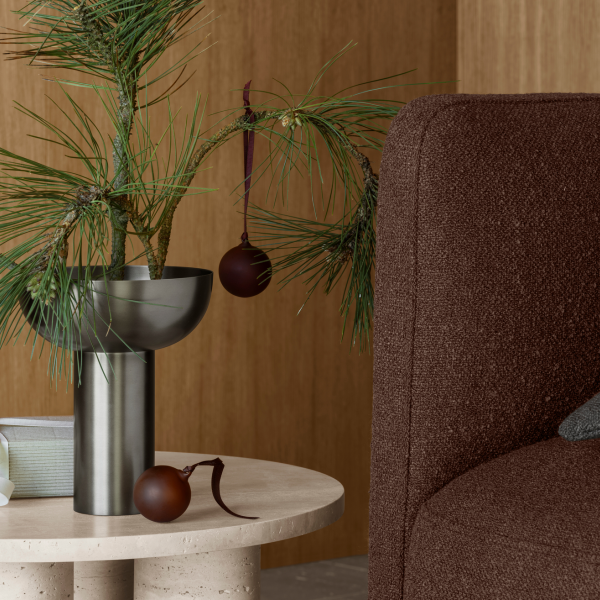 Stylische Urlaubsdekoration mit einem Tannenbaum und Ornamenten in einem modernen Wohnraum.
