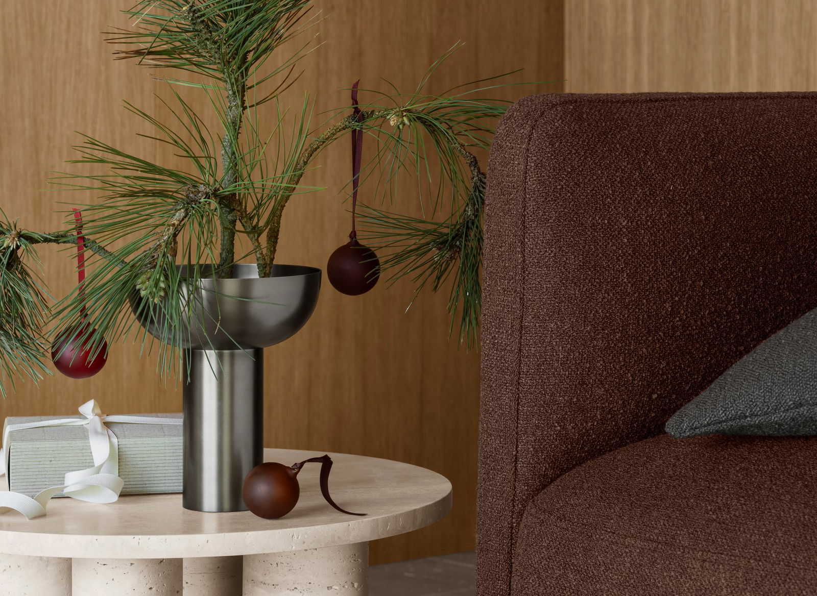 Stylische Urlaubsdekoration mit einem Tannenbaum und Ornamenten in einem modernen Wohnraum.