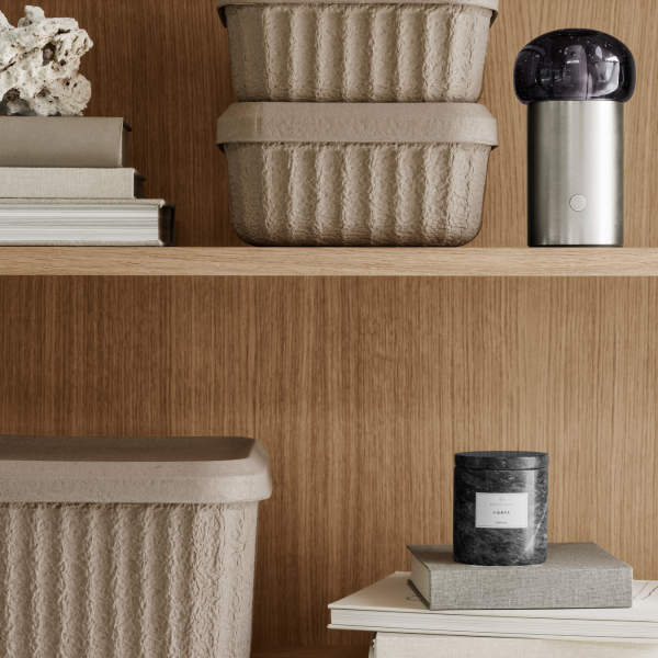 Moderne Wohnkultur mit strukturierten Aufbewahrungsboxen, einem eleganten Diffusor und einer duftenden Kerze.