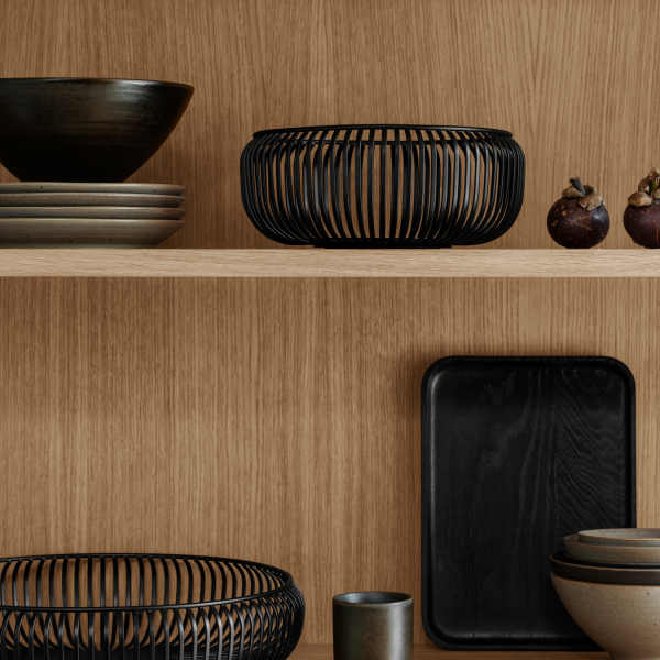 Stylish modern kitchen display featuring black and earthy ceramic dishes on wooden shelves.