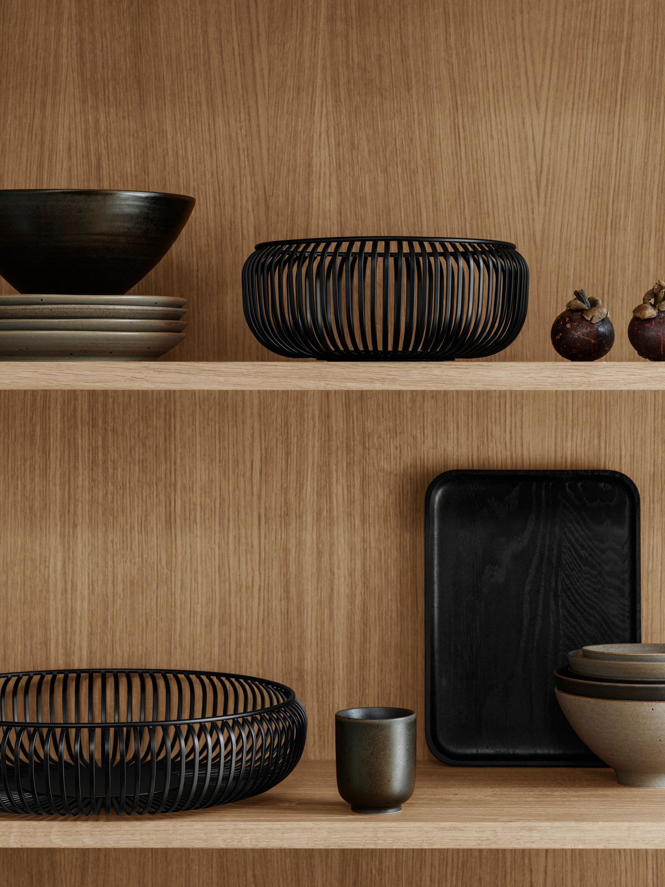 Stylish modern kitchen display featuring black and earthy ceramic dishes on wooden shelves.