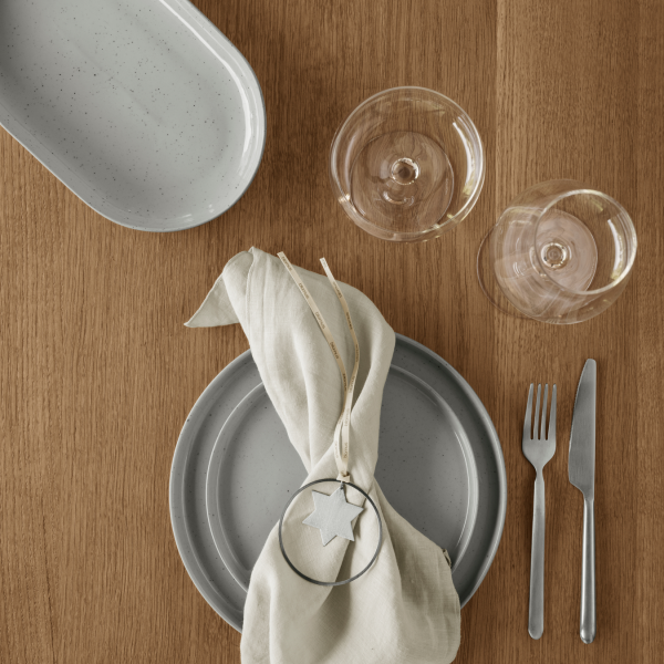 Elegante Tischdekoration mit Geschirr, Gläsern und einer dekorativen Serviette für einen besonderen Anlass.