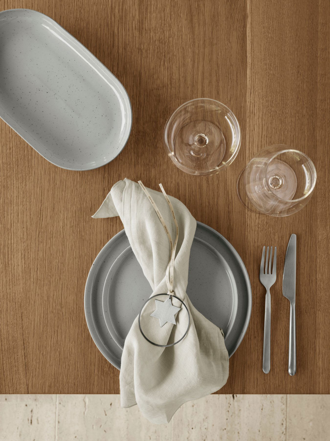 Elegante Tischdekoration mit Geschirr, Gläsern und einer dekorativen Serviette für einen besonderen Anlass.