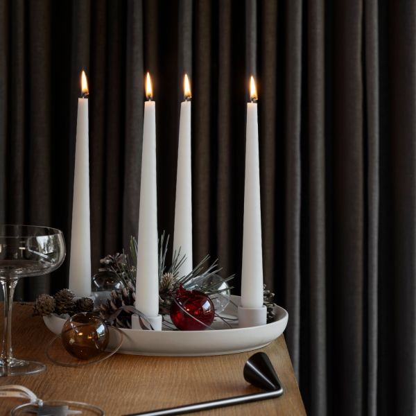 Elegant Christmas centerpiece with lit candles, pinecones, and decorative ornaments.