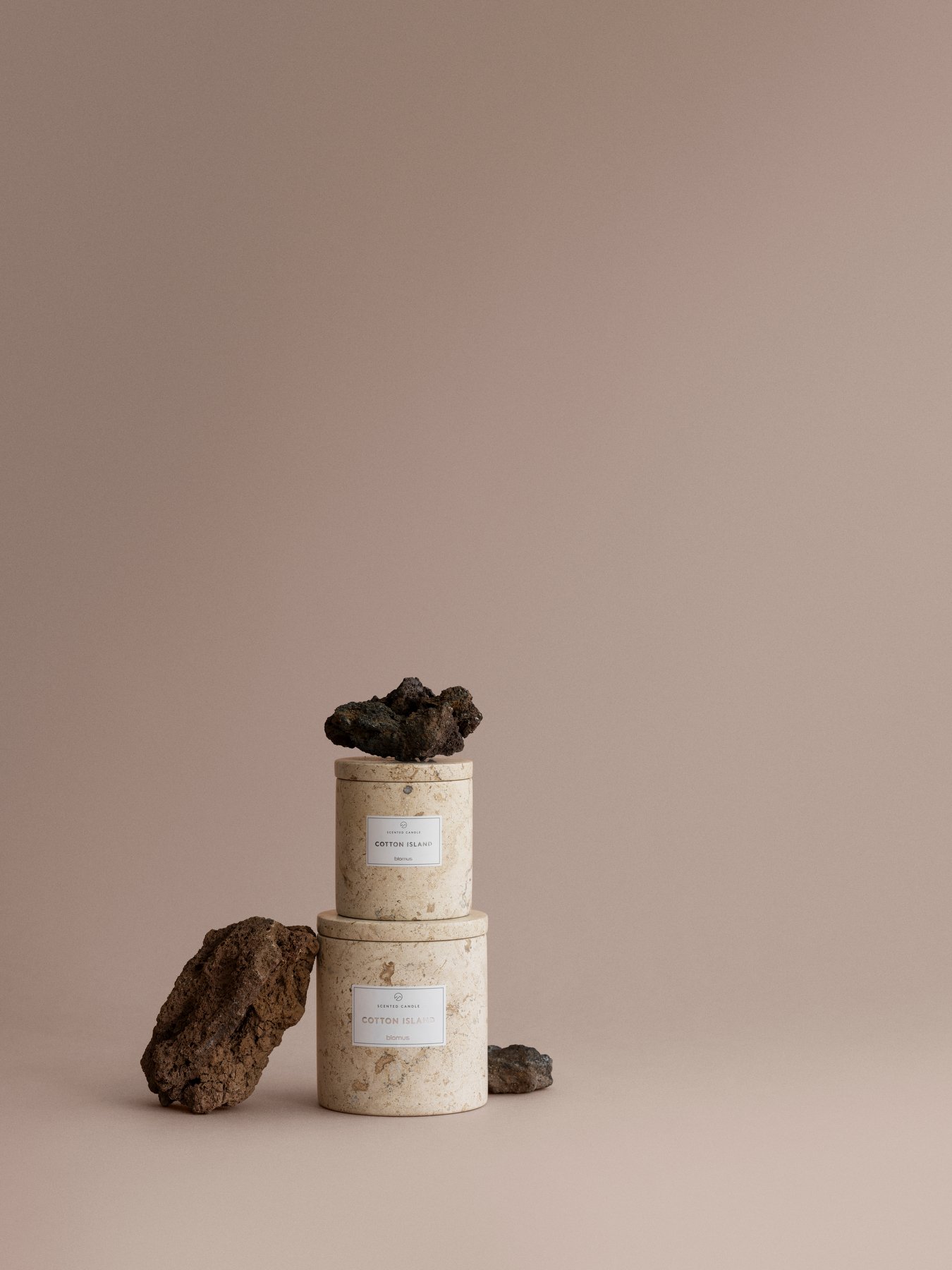 Elegant cotton candle jars with natural stone accents on a minimalist backdrop.