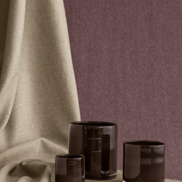 Elegante schwarze Glas-Teelichthalter vor einem strukturierten Stoffhintergrund.