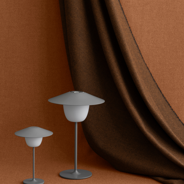 Stylische graue Lampen neben einem strukturierten braunen Vorhang für moderne Inneneinrichtung.