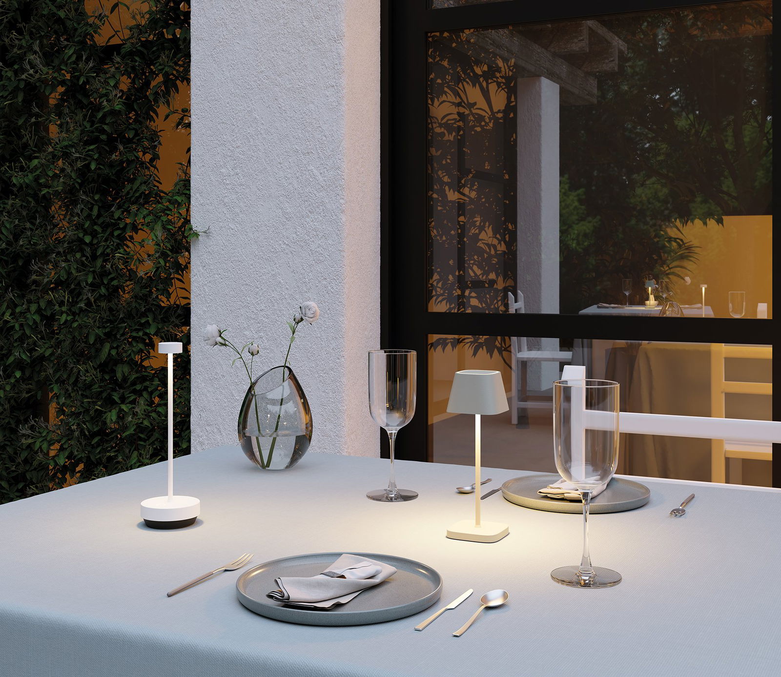 Elegante Außengastronomie mit sanfter Beleuchtung, modernem Geschirr und floraler Dekoration.