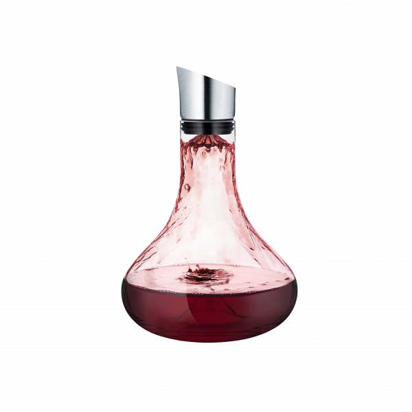 Elegant glass wine decanter pouring rich red wine.
