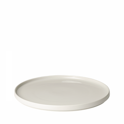 Minimalist white ceramic plate with a smooth, round surface.