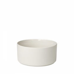 Minimalist white ceramic bowl with a smooth, curved design on a black background.