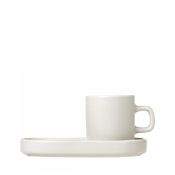 Simple white ceramic cup and saucer on a black background.
