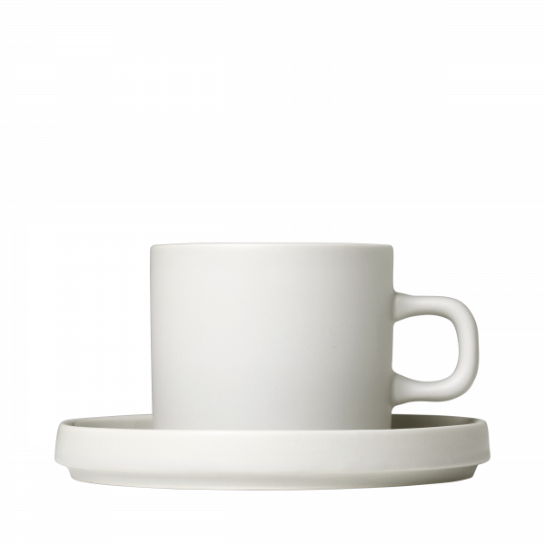 Minimalistische weiße Keramiktasse und Untertasse vor einem schwarzen Hintergrund.
