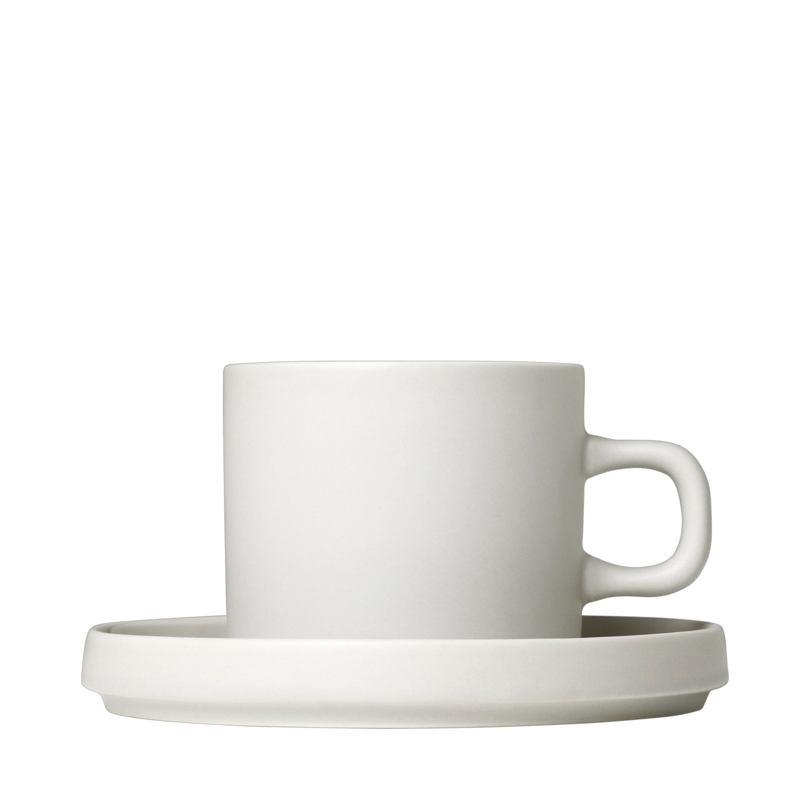 Minimalistische weiße Keramiktasse und Untertasse vor einem schwarzen Hintergrund.