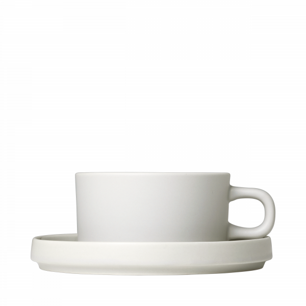 Minimalistische weiße Kaffeetasse mit Untertasse auf einem schwarzen Hintergrund.
