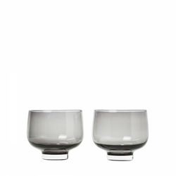 Set von zwei eleganten grauen Glas-Trinkbechern auf schwarzem Hintergrund.