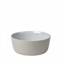 Minimalist white ceramic bowl with a speckled finish on a black background.