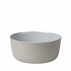 Minimalist ceramic bowl with a speckled exterior and smooth white interior.