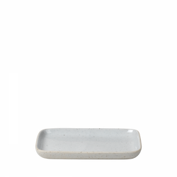 Minimalist rectangular white ceramic plate on a black background.