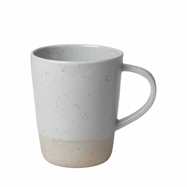 Keramiktasse mit einem gesprenkelten Design und einem kontrastierenden Akzent aus natürlichem Ton auf schwarzem Hintergrund.