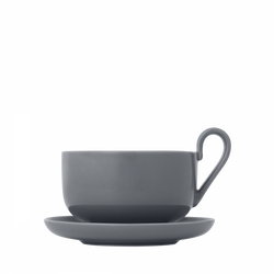 Grey ceramic cup and saucer set on a black background for modern dining aesthetics.
