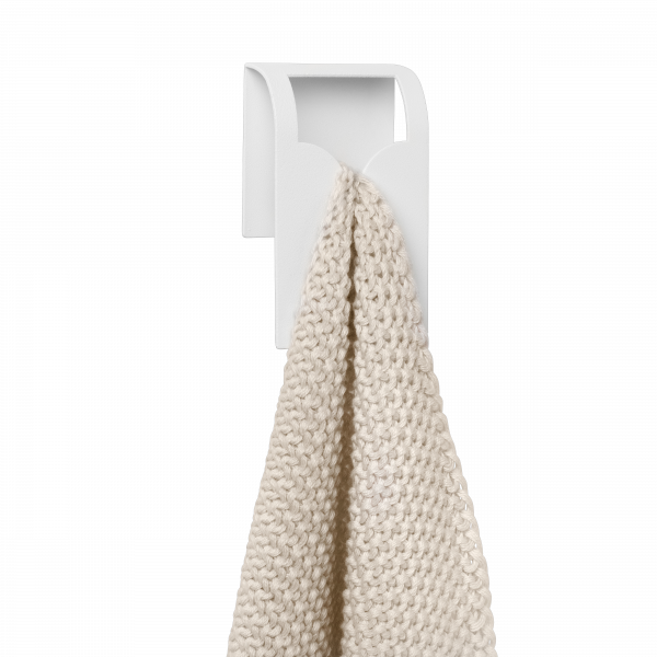 Minimalist weißer Handtuchhalter mit einem weichen, beige gestrickten Handtuch, das daran hängt.