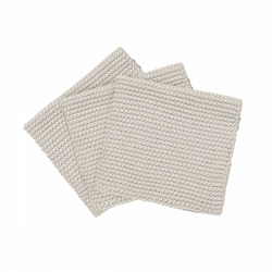 Three soft, beige knitted dishcloths stacked neatly on a black background.