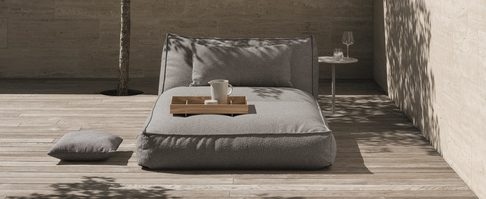 cozy outdoor lounge chair with soft grey cushions and wooden tray on wooden patio floor