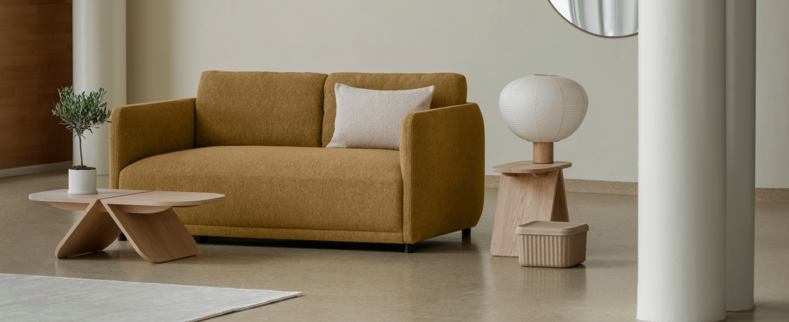 Gemütliches modernes Wohnzimmer mit braunem Sofa, Holz-Beistelltischen und stilvoller Lampe.