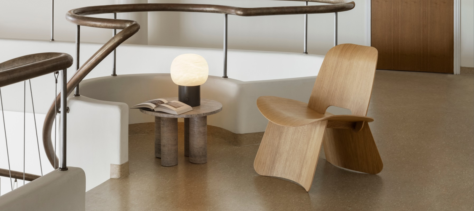 Moderne Holzstuhl neben Tisch und Lampe in einem eleganten Innenraum.
