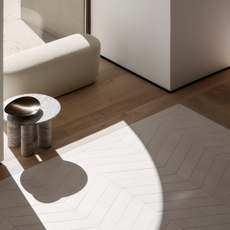 Modern living space featuring stylish furniture and natural light illuminating wooden flooring.