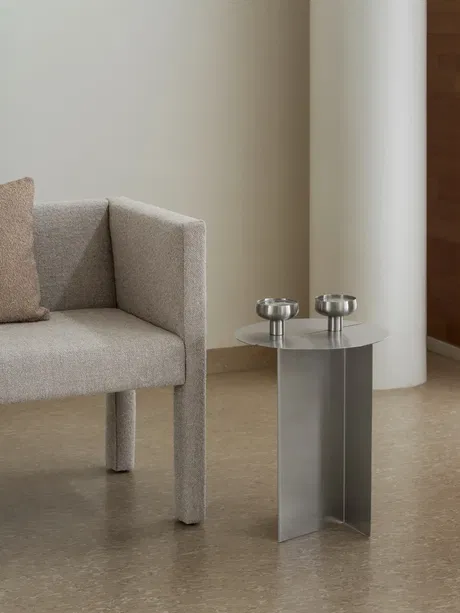 Moderner Wohnraum mit grauem Sofa und minimalistischer Metall-Tisch.