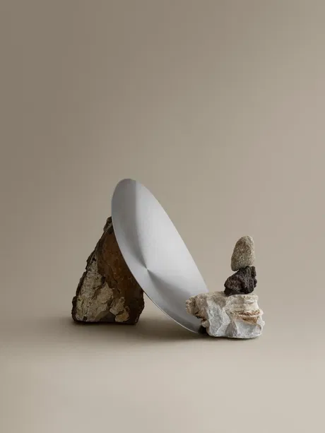 Moderne Schüssel auf Steinen, minimalistisches Design vor neutralem Hintergrund.