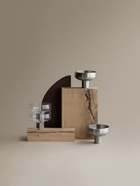Moderne Dekoration mit Holz- und Metallakzenten auf neutralem Hintergrund.