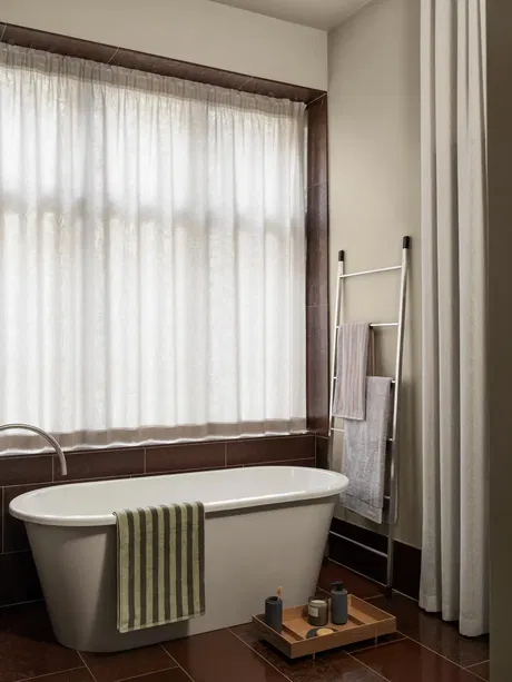 Elegantes Badezimmer mit freistehender Badewanne und natürlichem Licht.